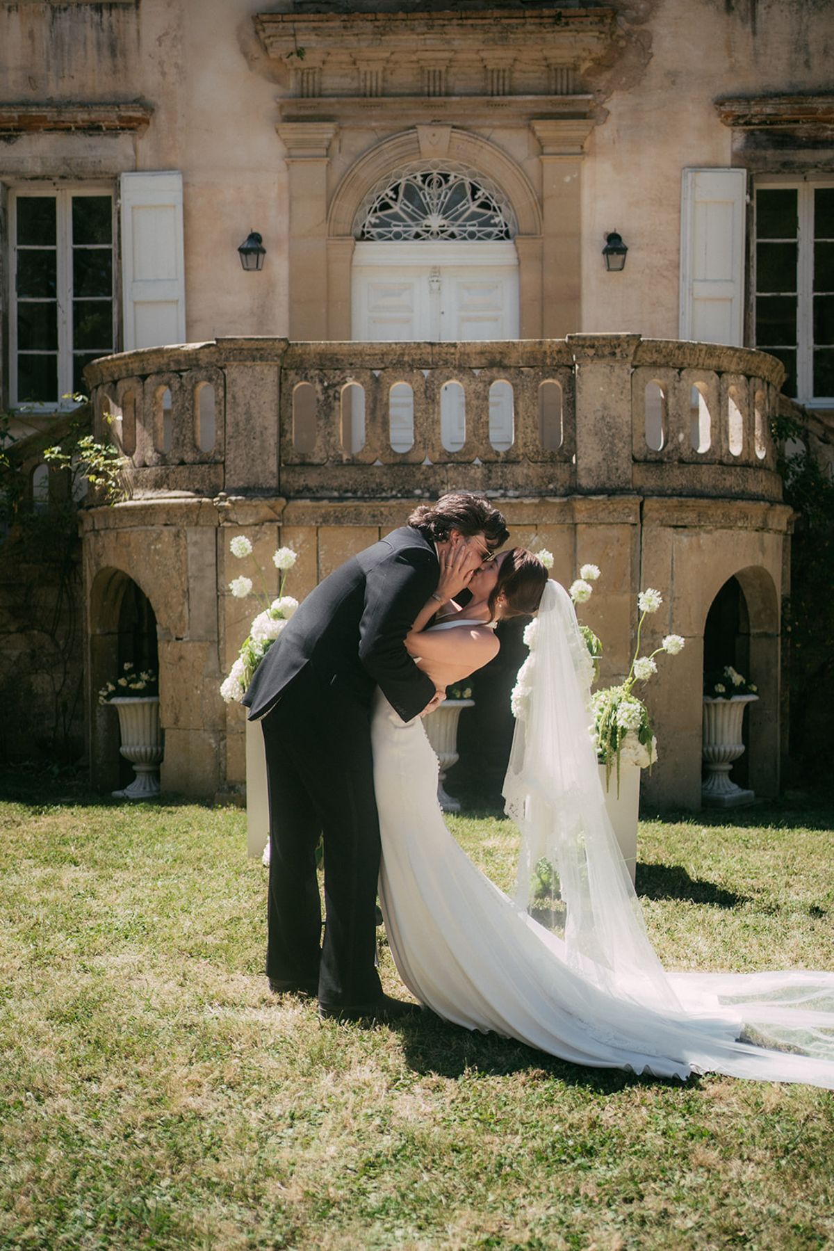 Jasmin and David kissing in front of the arcaded orangery