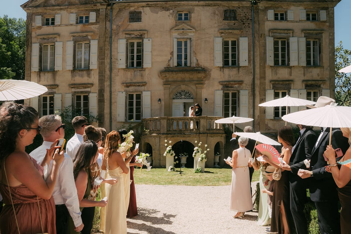 Guests with parasols in front of the chateau at Chateau du Pont Bourguet