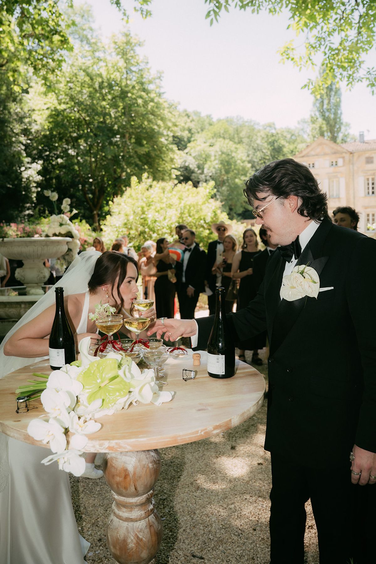 Jasmin and David at the drinks table, guests behind them