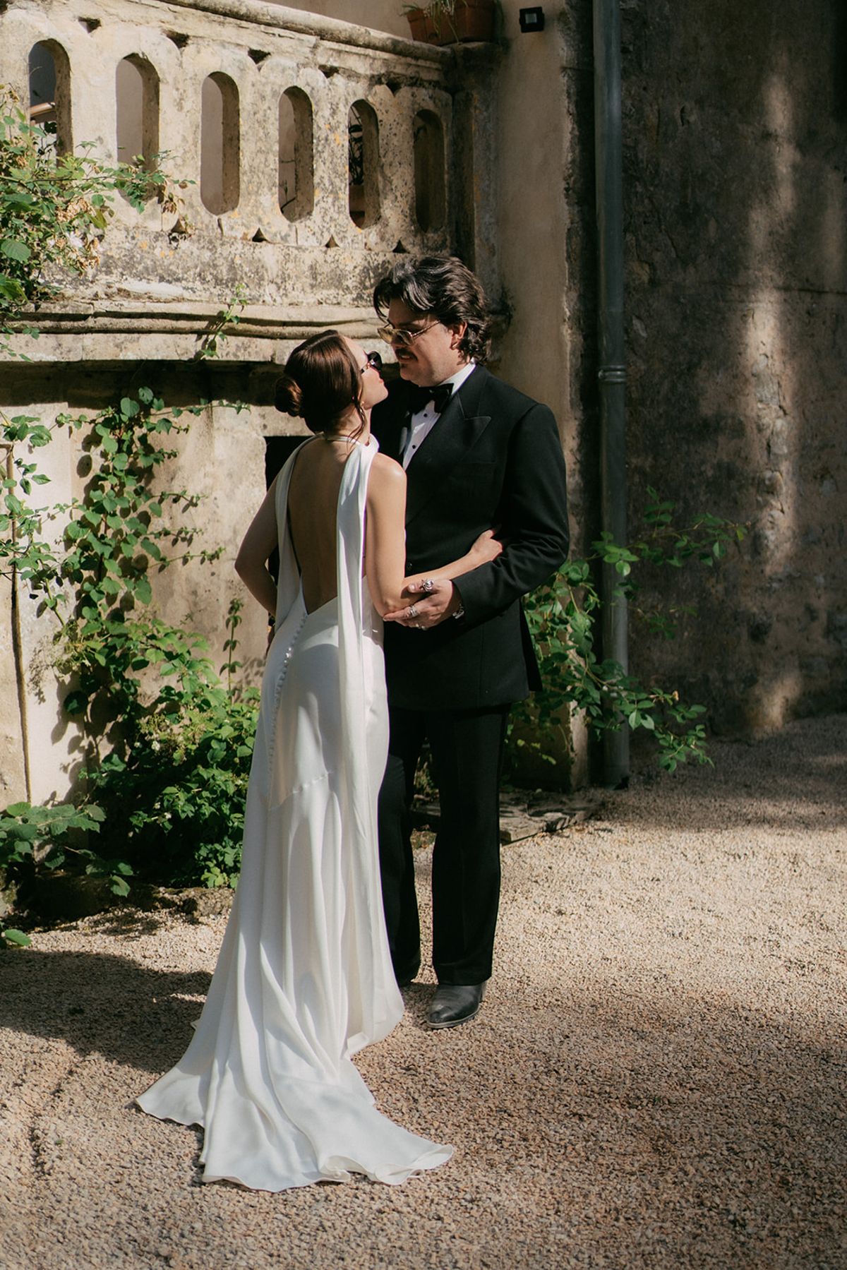 Jasmin and David against the stone wall and greenery