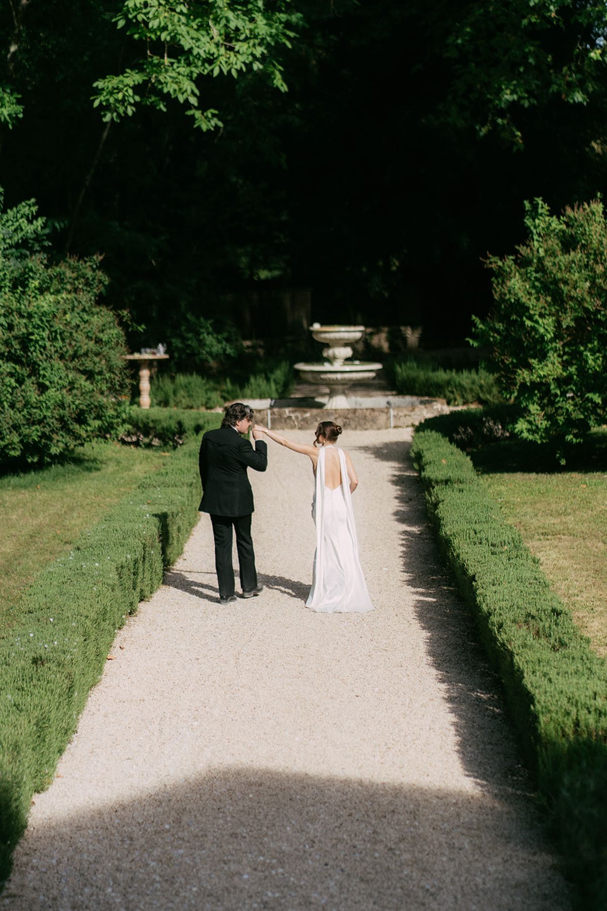 Jasmin and David walking the hedged path towards the fountain