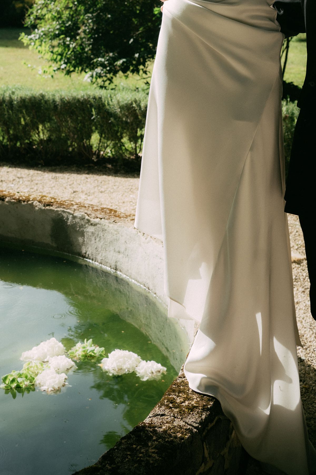 The bride's train falling across the fountain basin