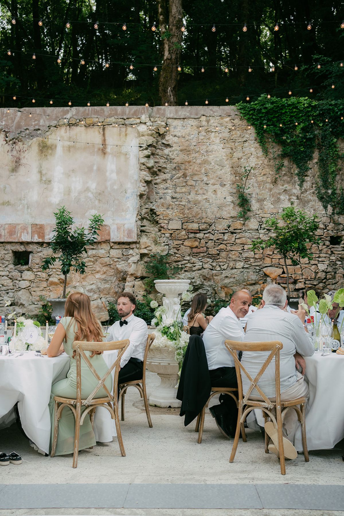 Guests dining beside the stone wall at Chateau du Pont Bourguet
