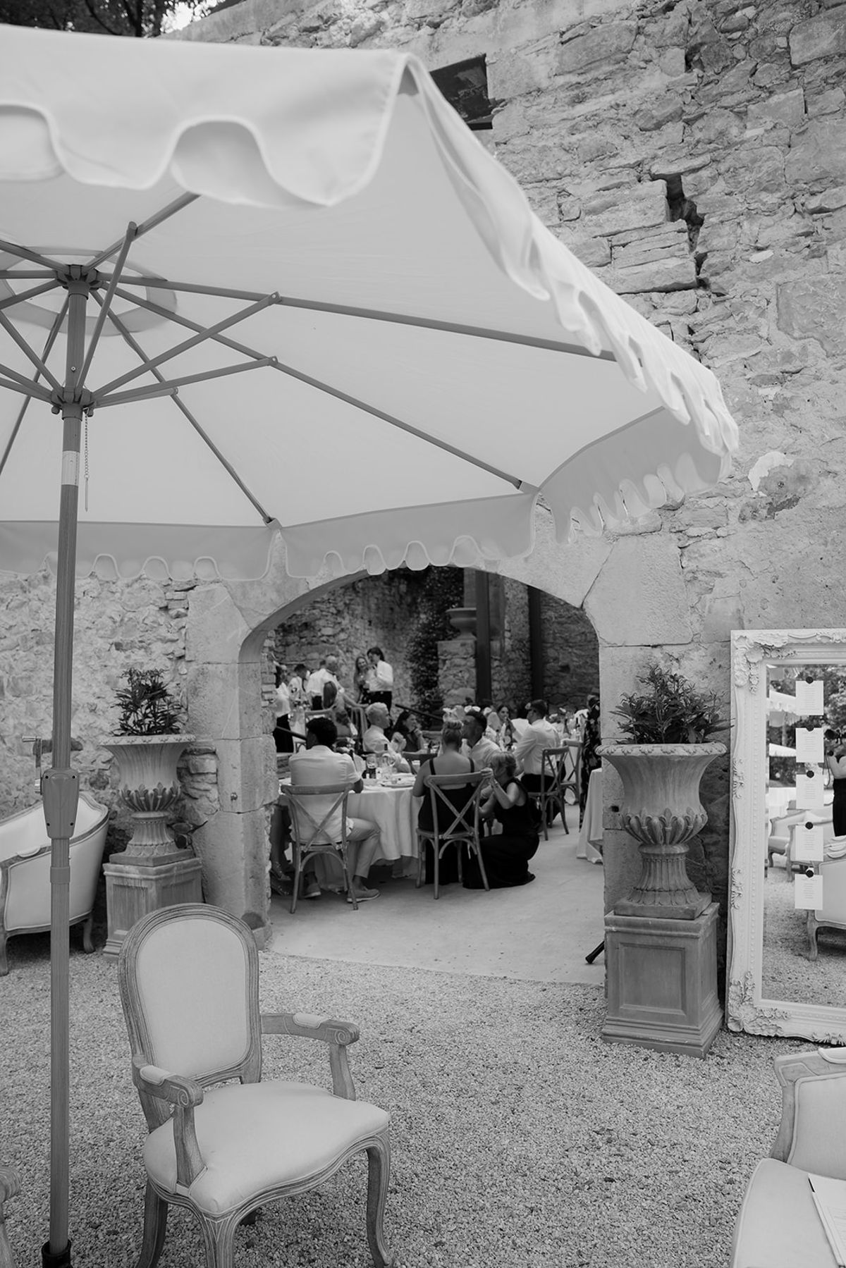 Guests seated for dinner through the stone arch at Chateau du Pont Bourguet