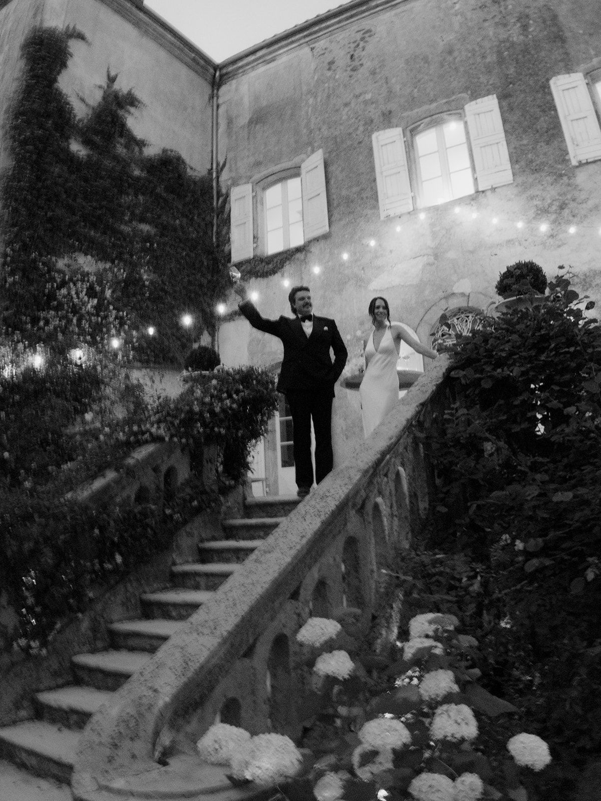 Jasmin and David on the chateau staircase under festoon lights