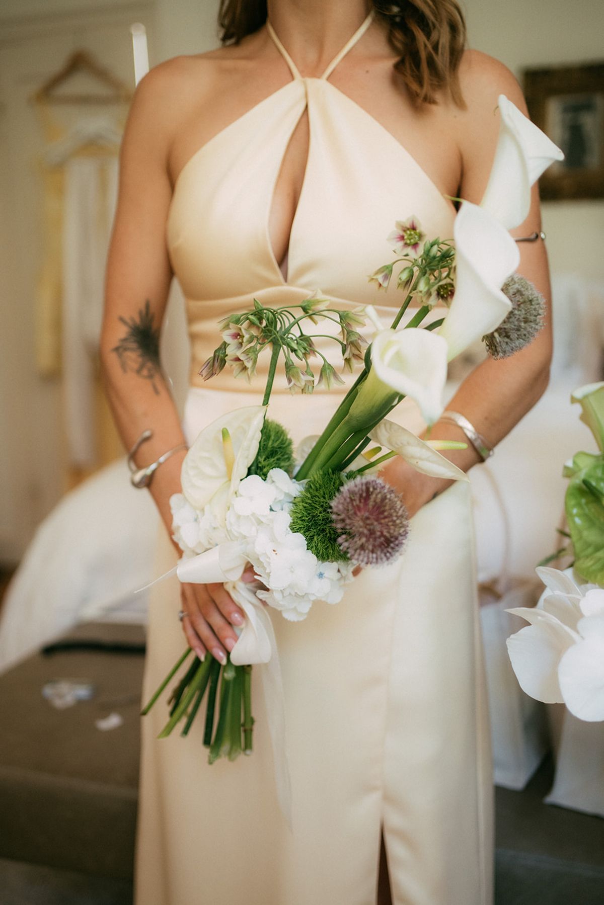 Close-up of the bride's bouquet against her halter-neck gown