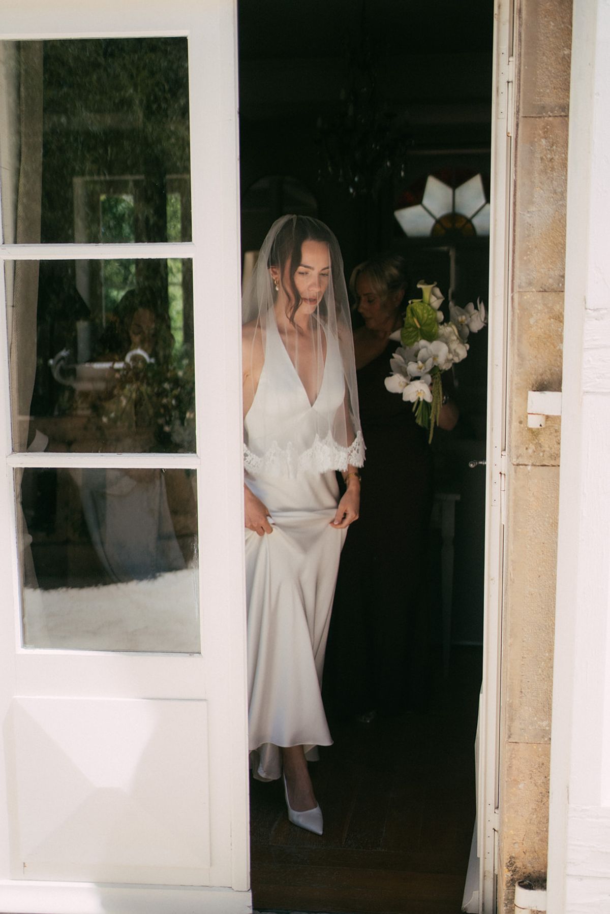 The bride in the doorway with her bouquet before the ceremony