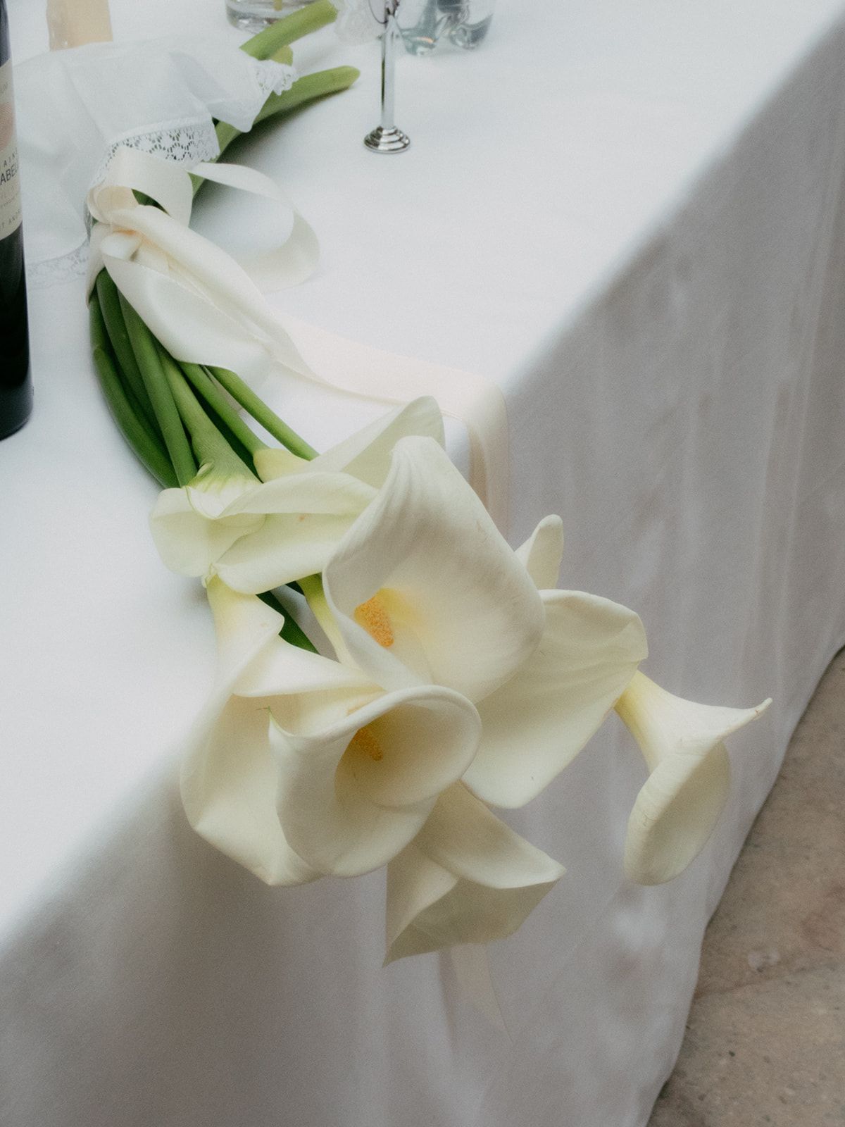 Calla lily bouquet on a white surface at Chateau du Pont Bourguet