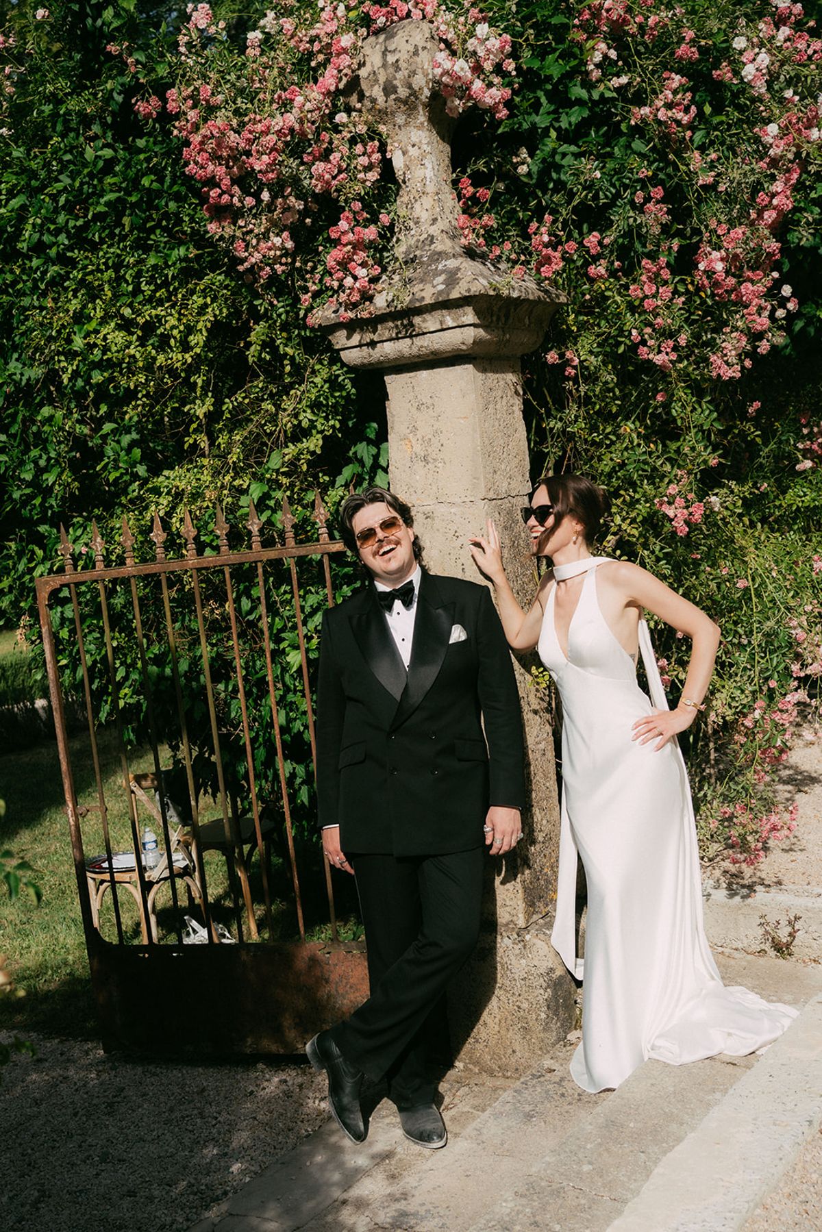 Jasmin and David at the iron gate under climbing roses