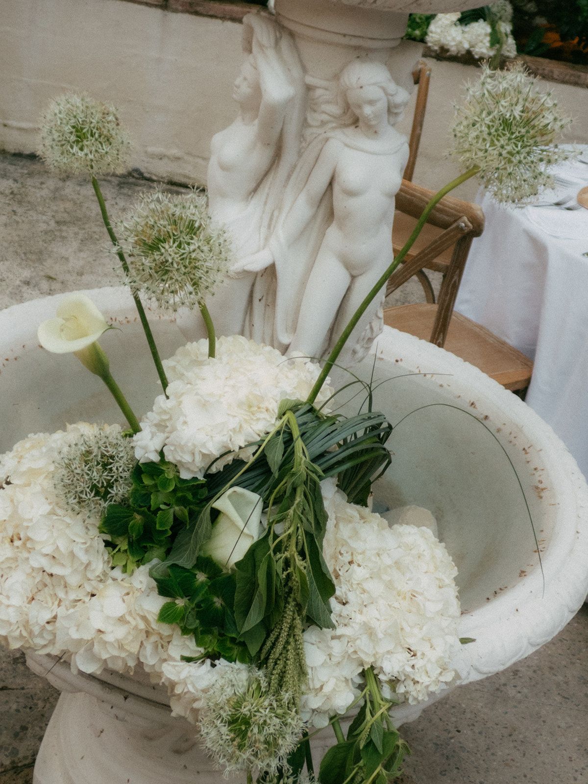 White hydrangea and calla arranged in a stone urn at Chateau du Pont Bourguet