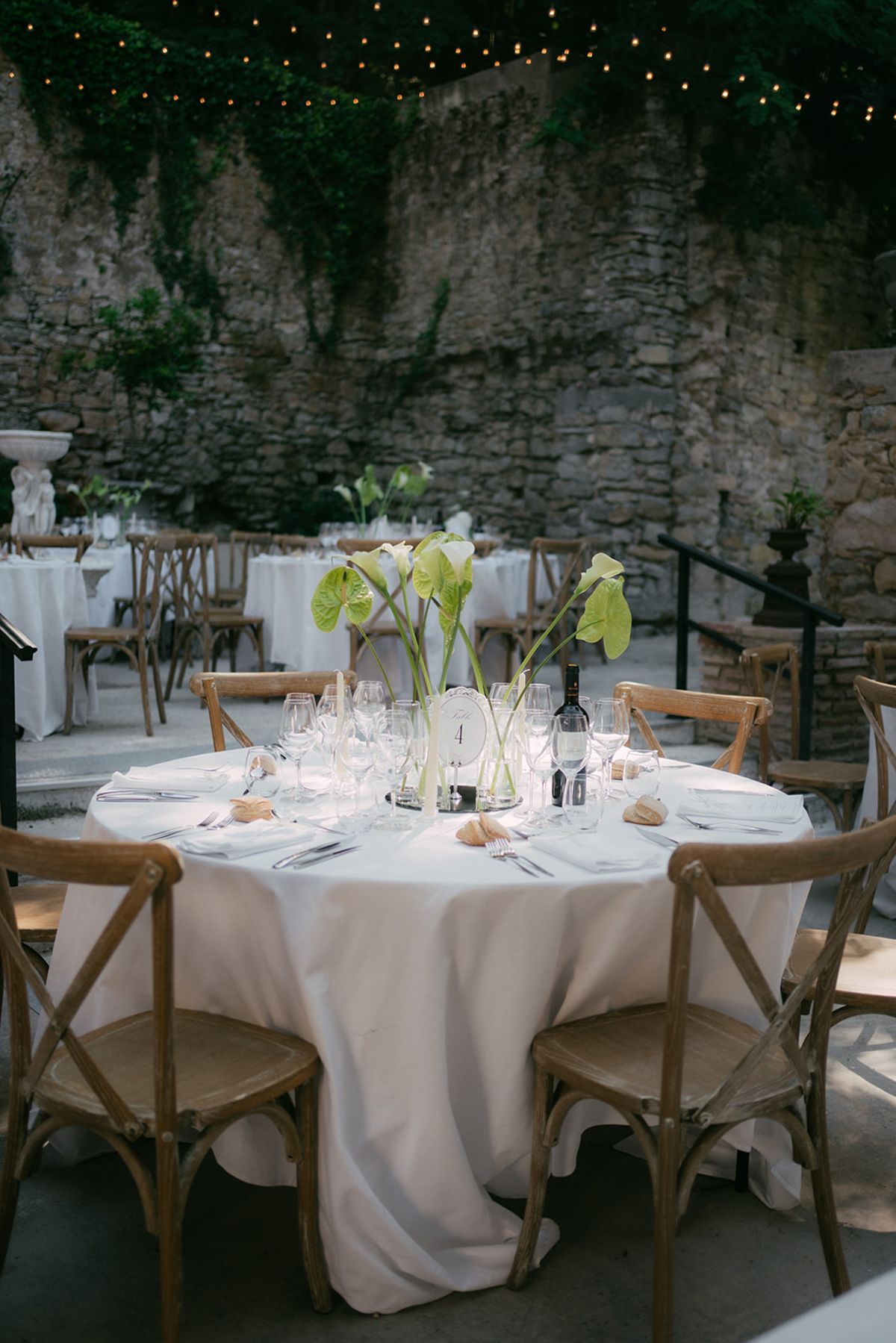 Round tables set for dinner in the barn at Chateau du Pont Bourguet