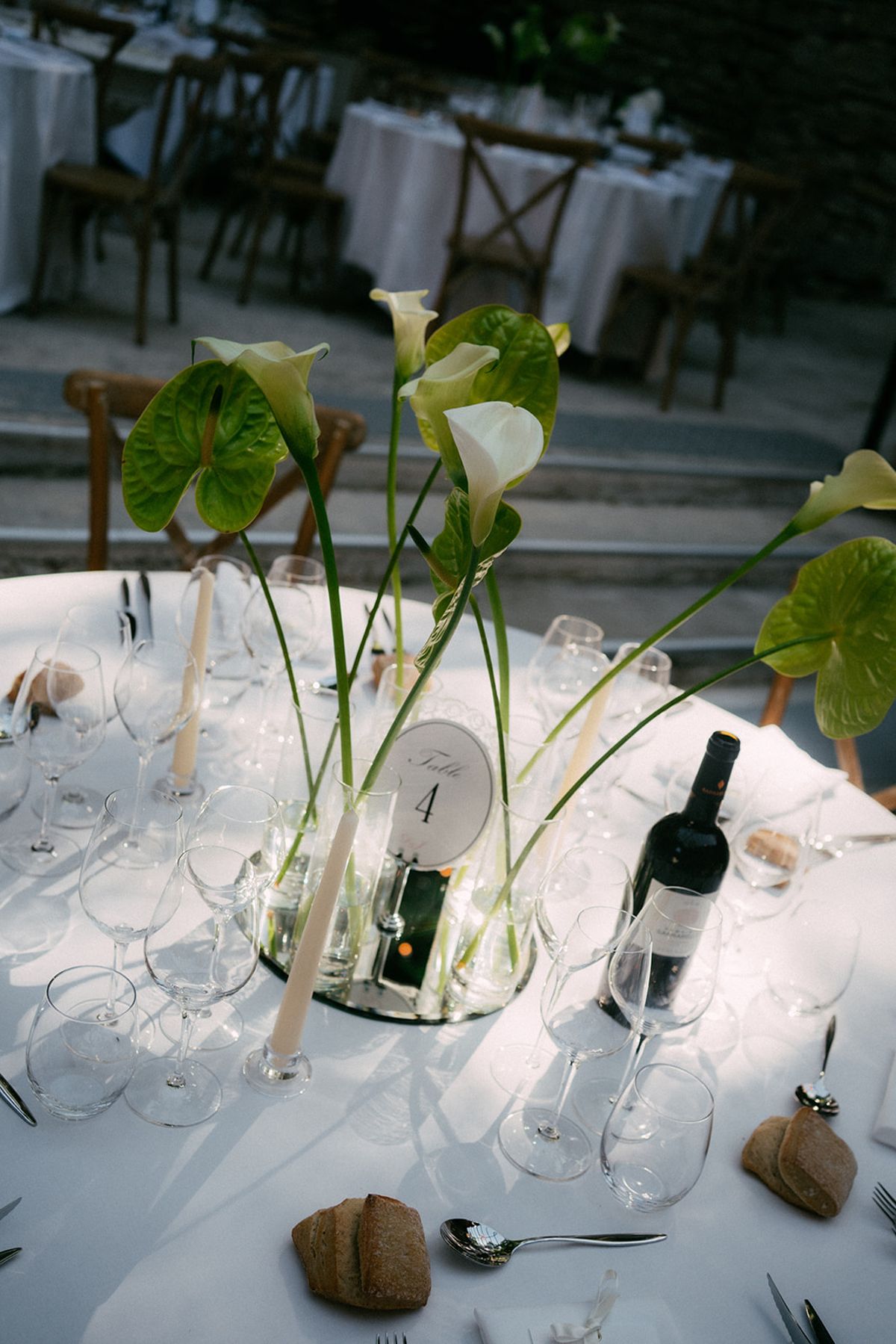 Table numbers and calla stems in glass on the dinner table