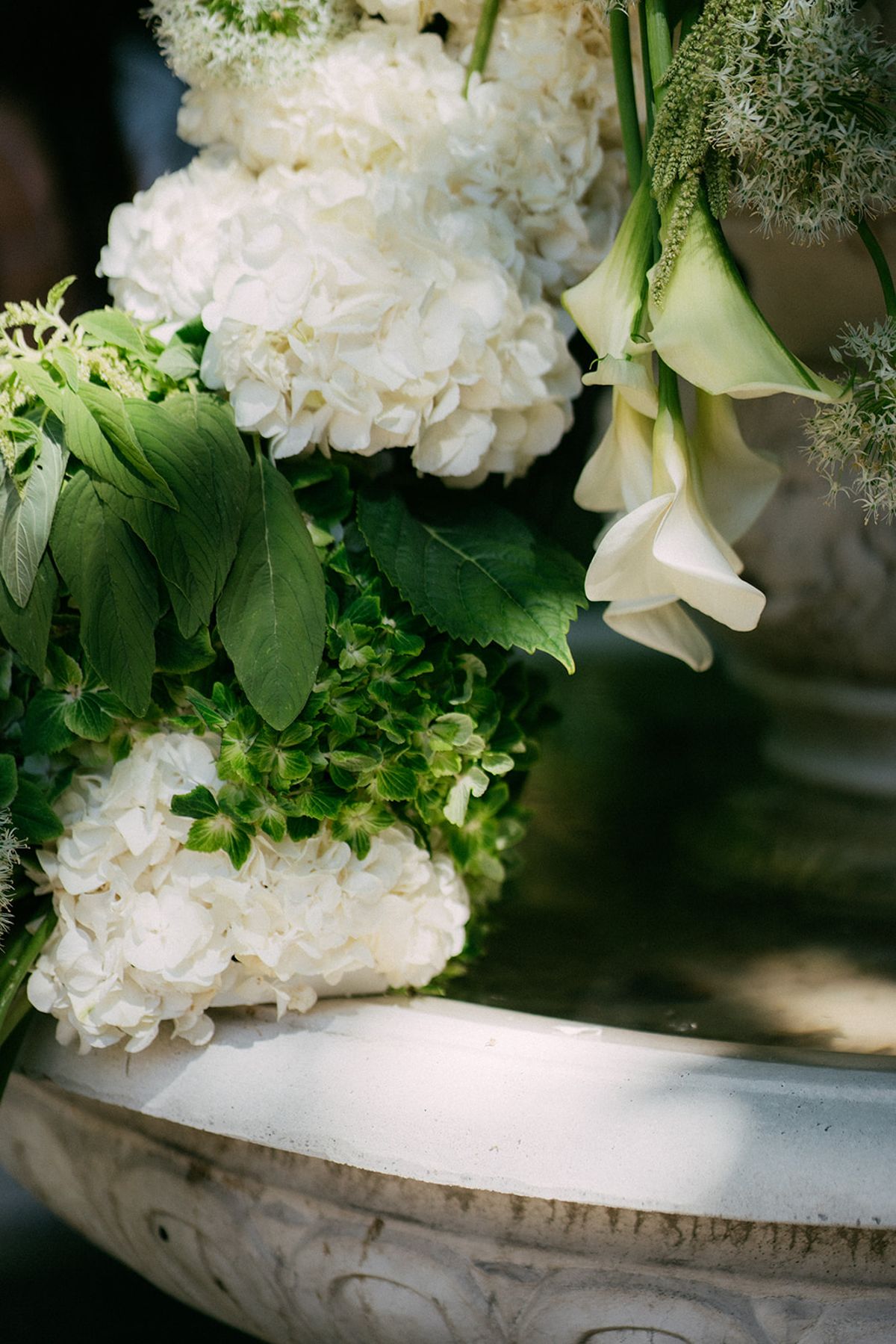White hydrangea and calla massed in a stone bowl