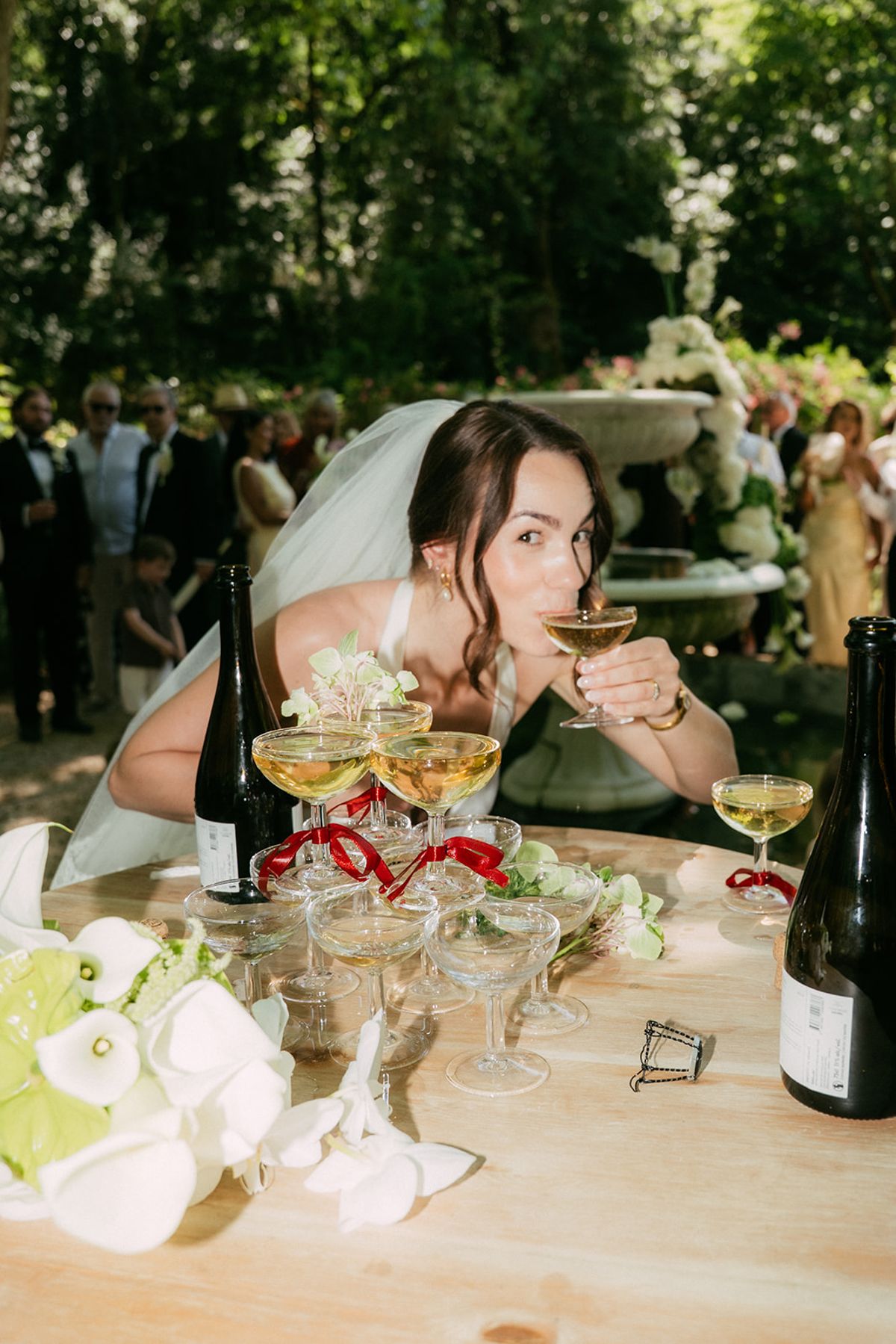 The bride drinking from a coupe at the champagne table