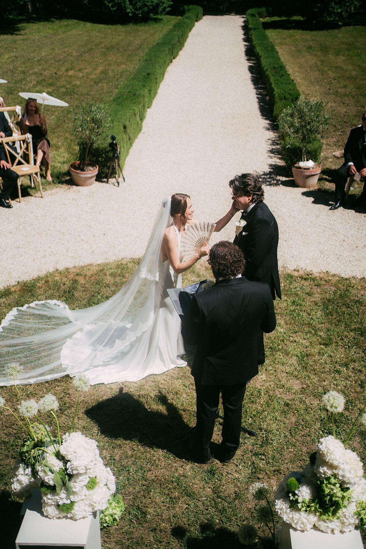 The bride on the aisle, her long veil trailing behind her