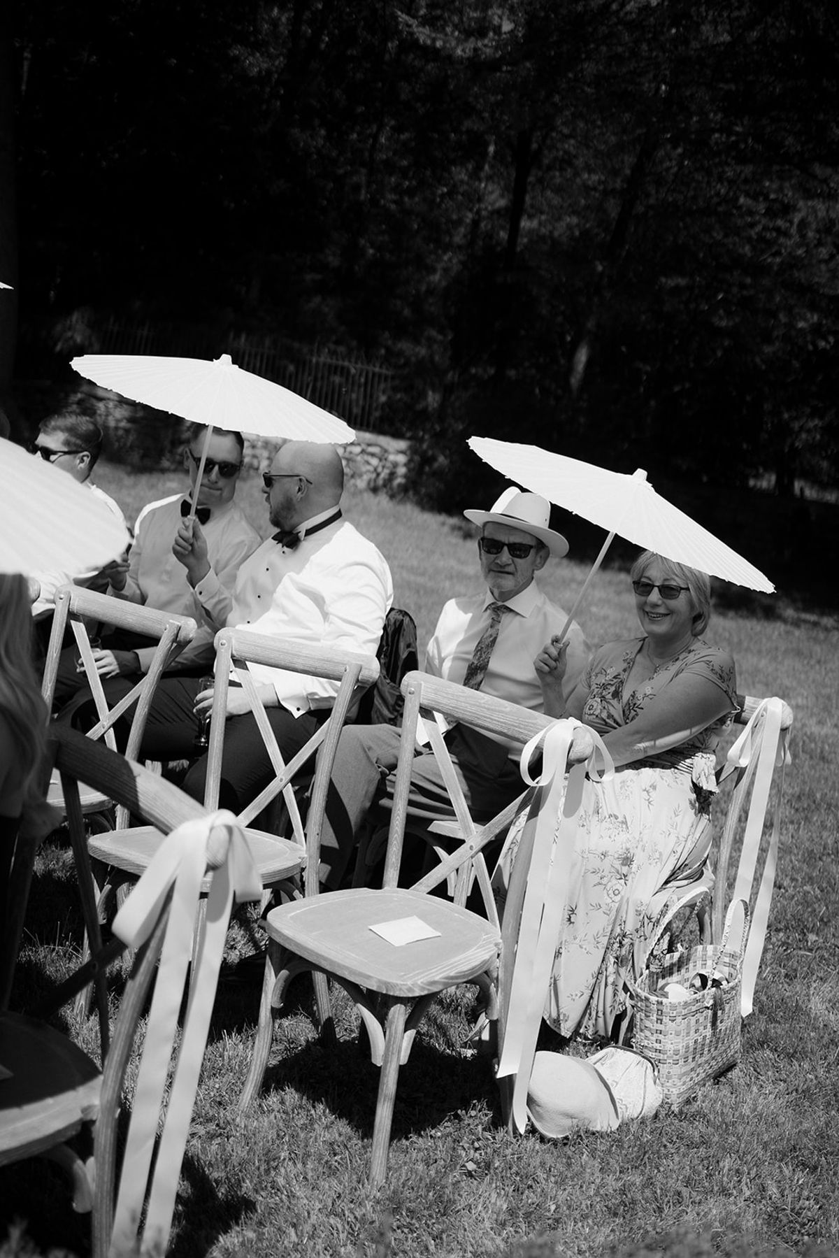 Guests sheltering under parasols on the ceremony chairs