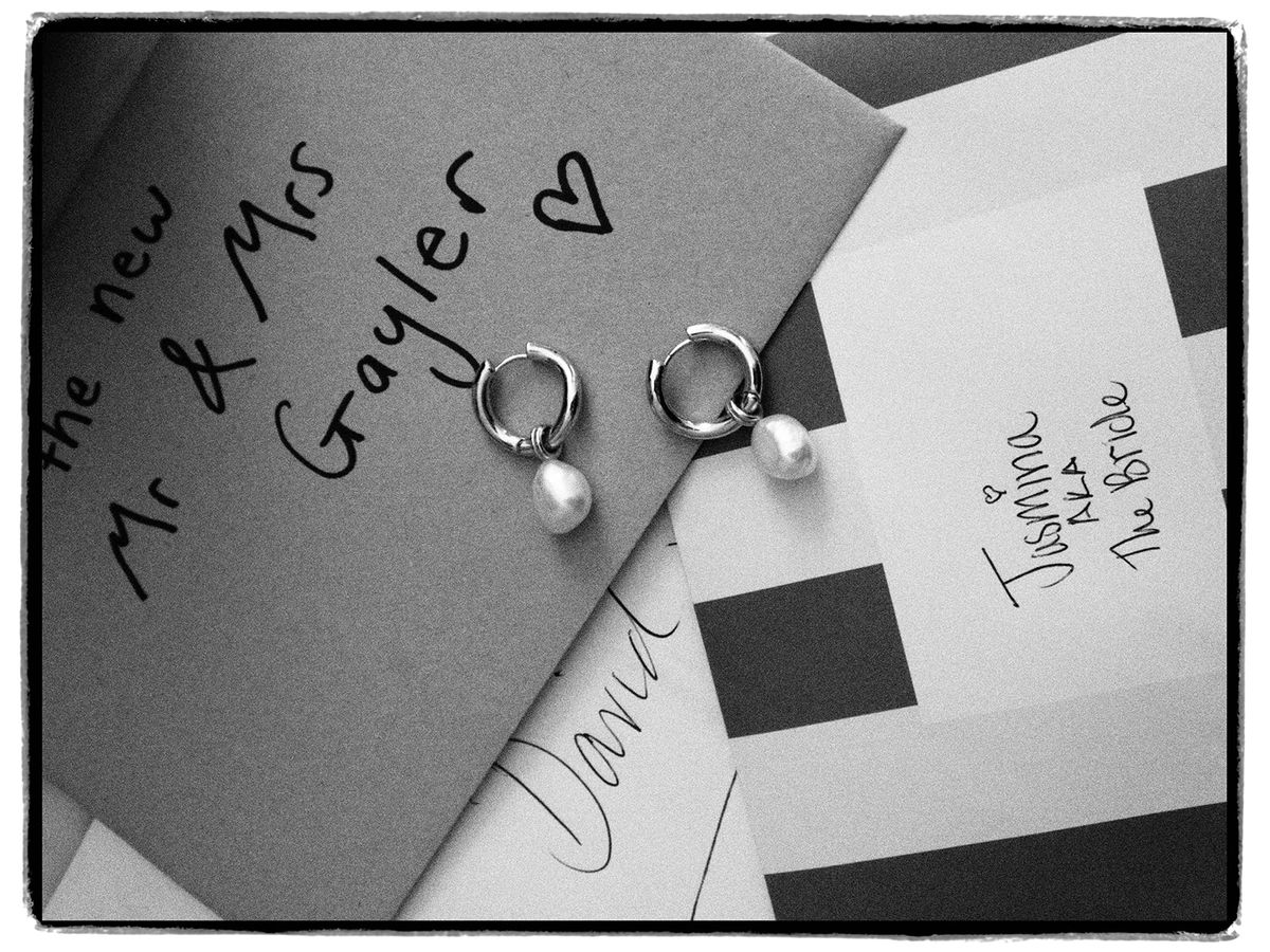Place cards and pearl earrings laid out before the wedding of Jasmin and David