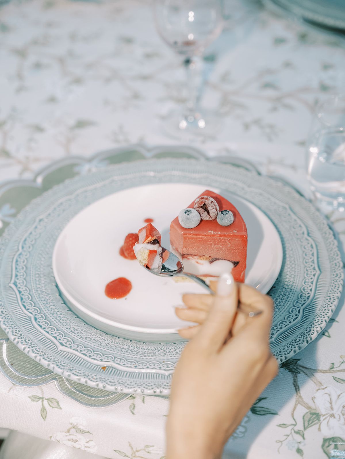 A slice of the red glazed cake on scalloped china