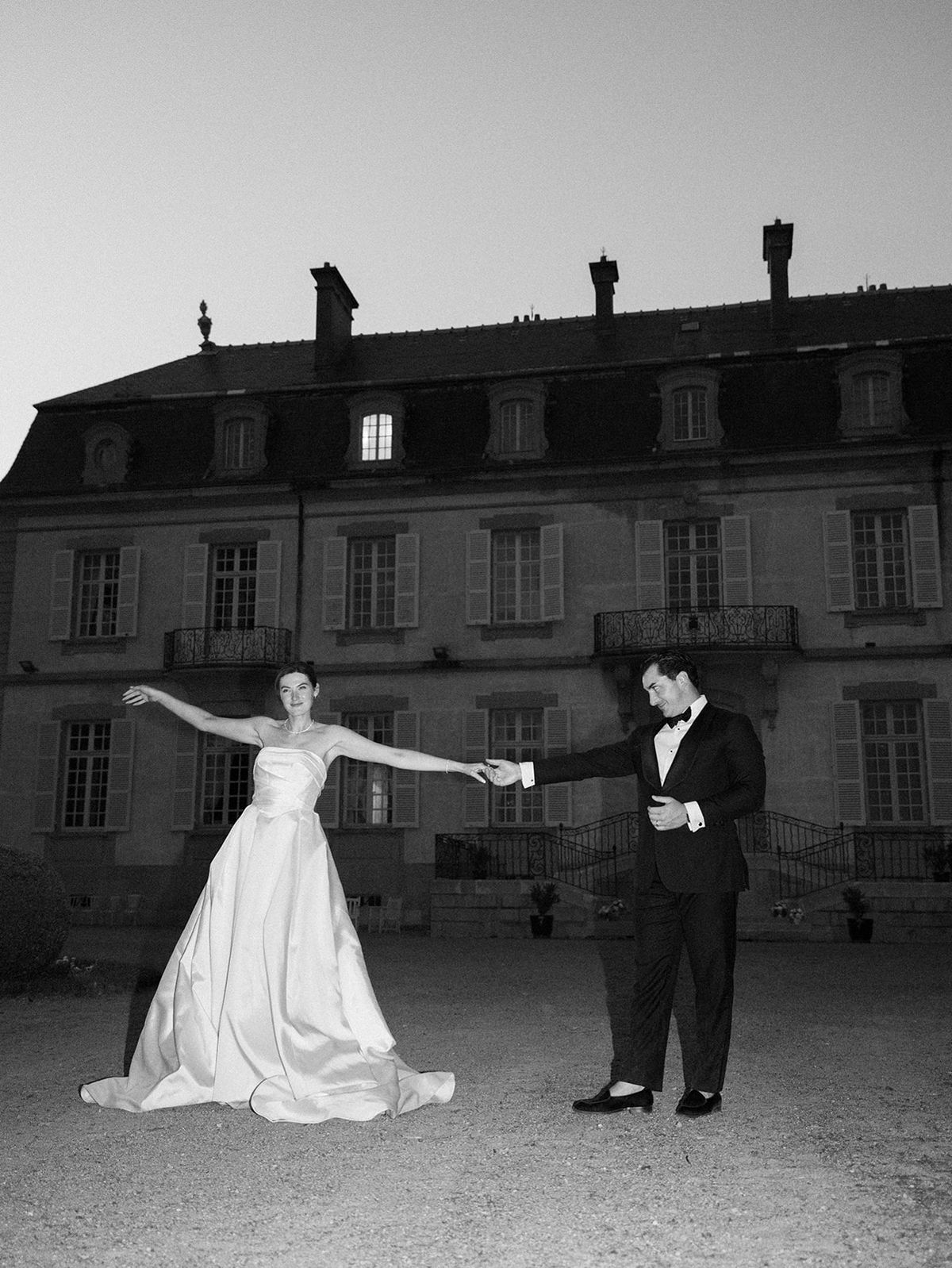 Haley and Tyler dancing in front of the lit facade of La Chassagne