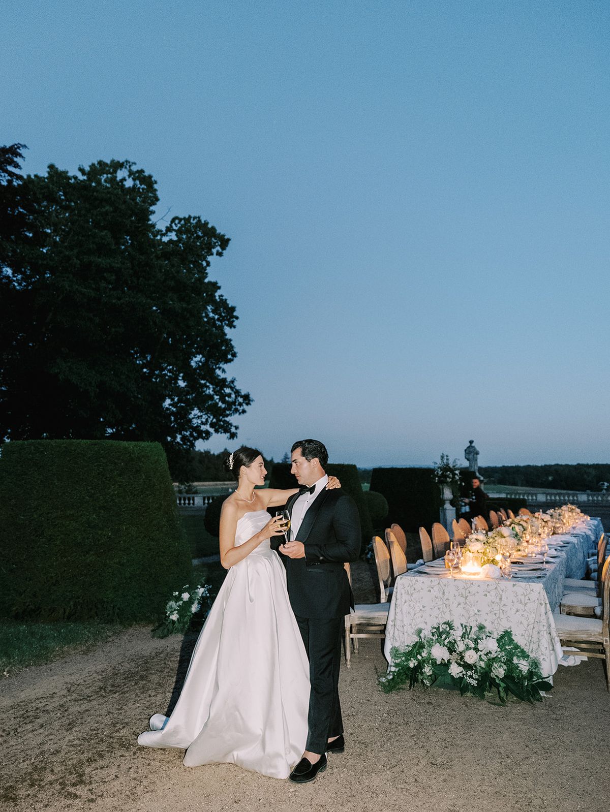 Haley and Tyler beside the candlelit table as dusk falls