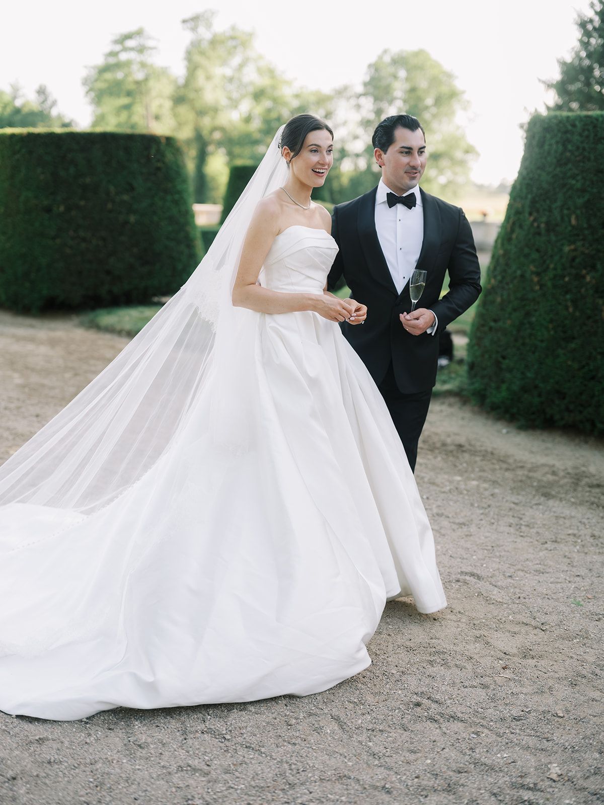 Haley and Tyler walking the gravel path between the topiary