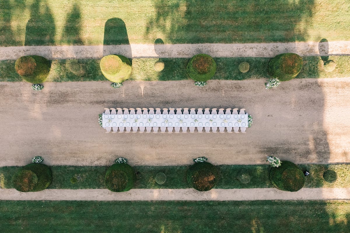 The long dinner table set along the garden allee, from above