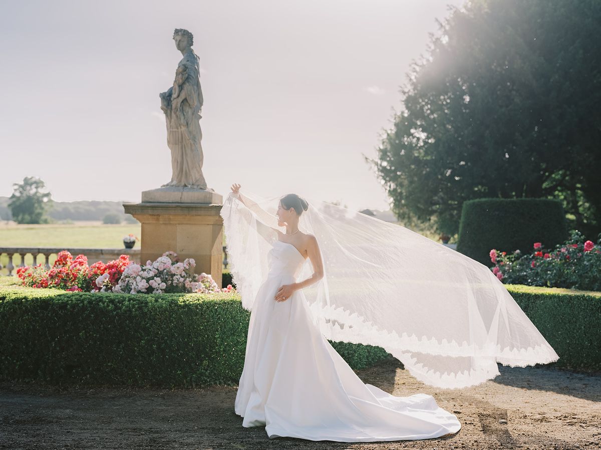 Haley with her veil catching the light below the statue