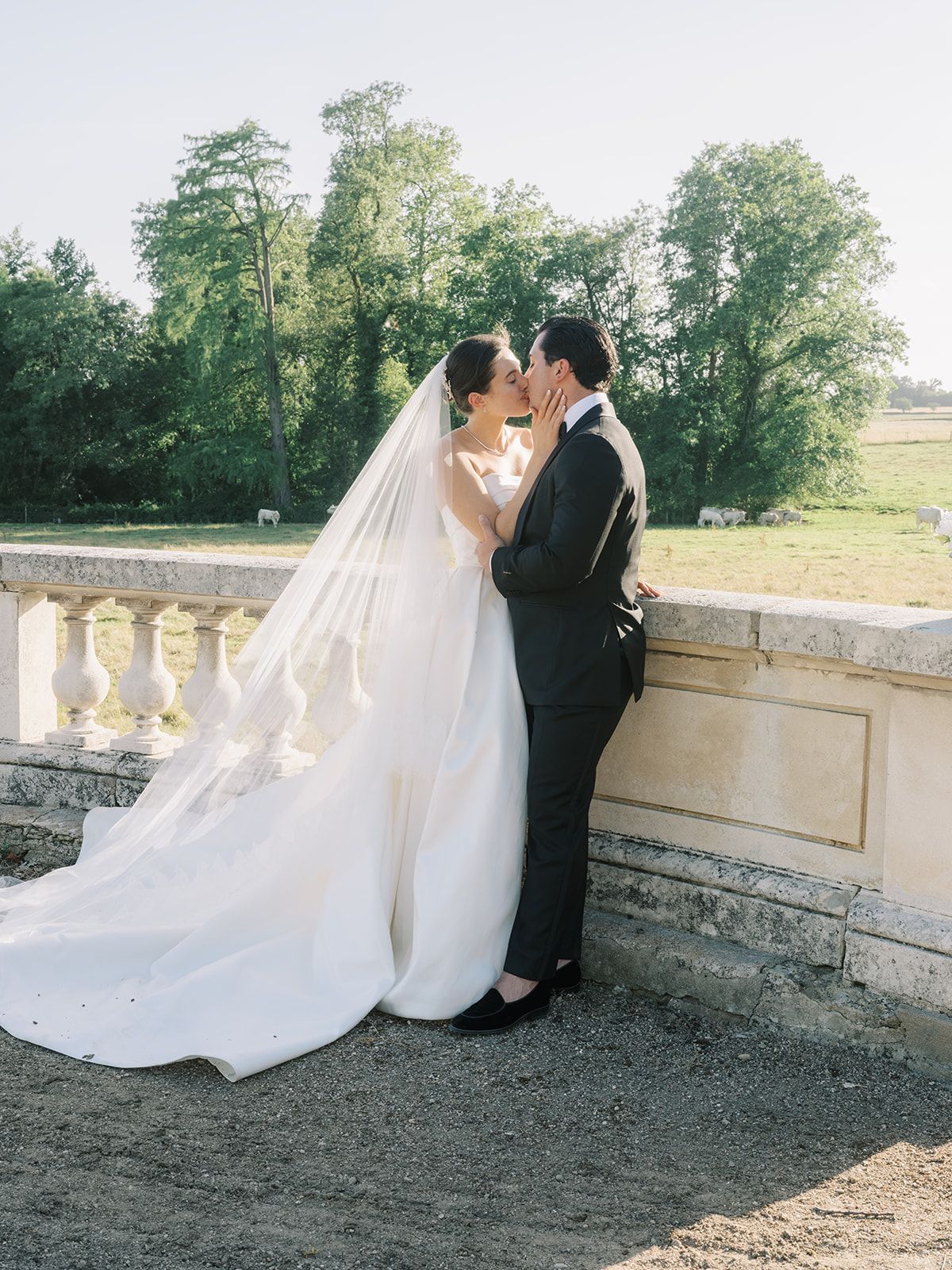 Haley and Tyler kissing at the balustrade above the fields