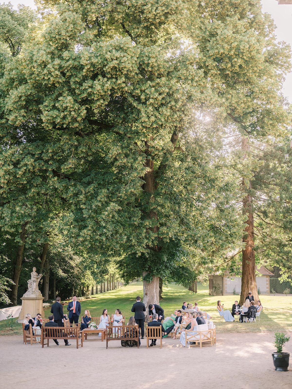 Guests in garden lounge seating beneath the trees
