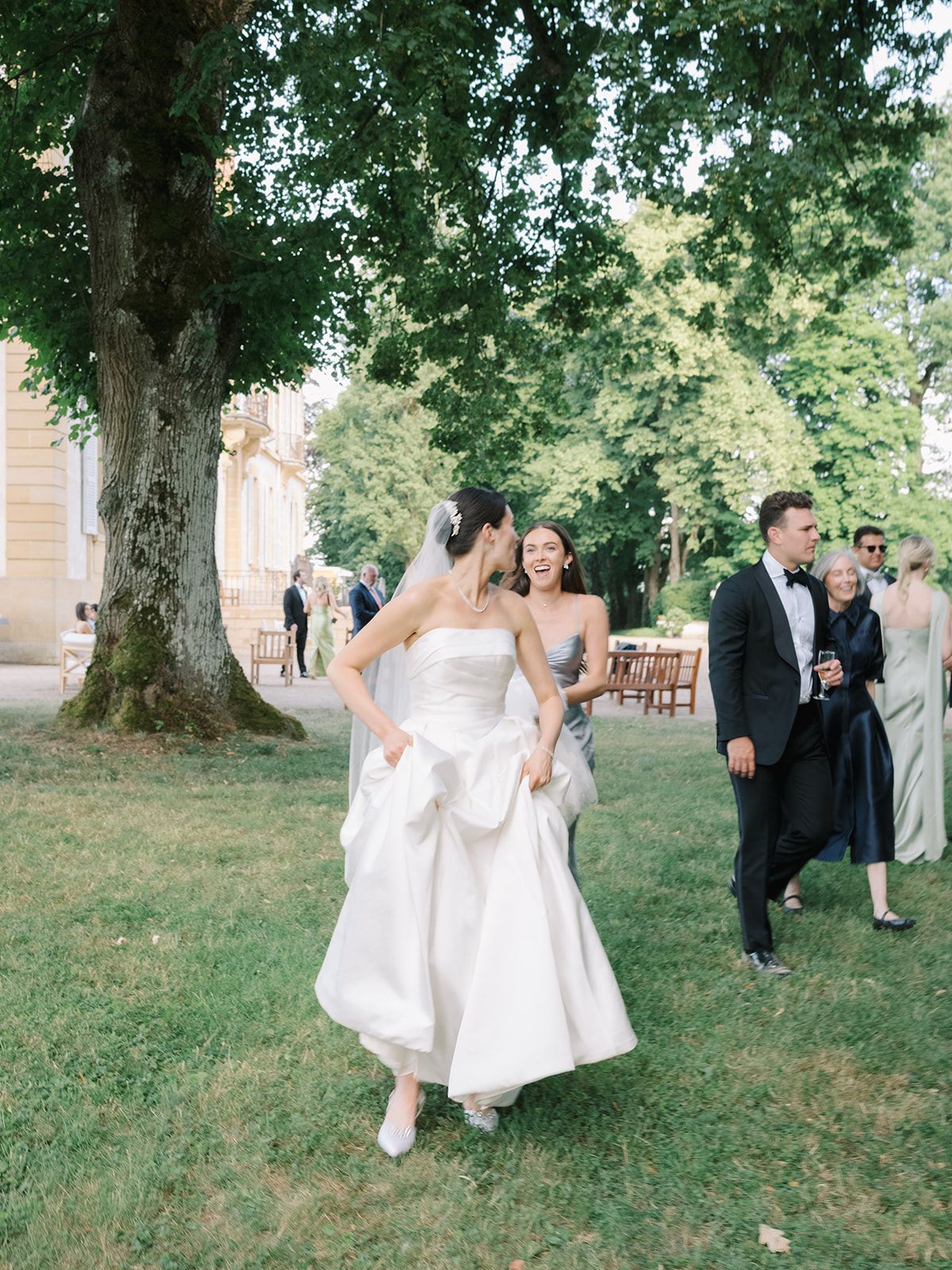 Haley crossing the lawn as guests gather under the trees