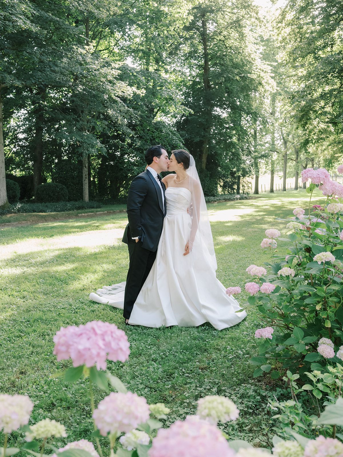 Haley and Tyler kissing beside the hydrangeas