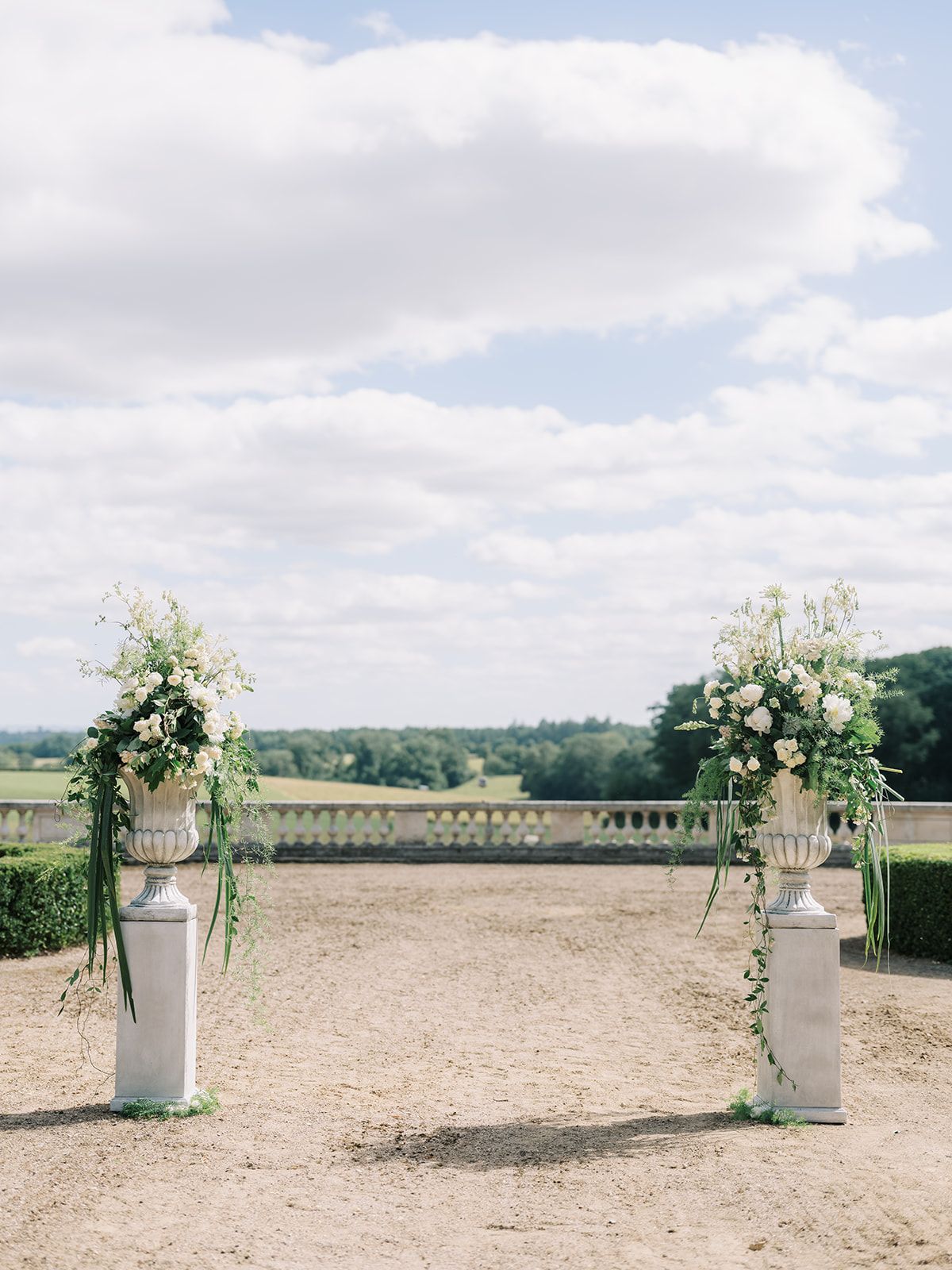 Urns of white flowers marking the head of the aisle