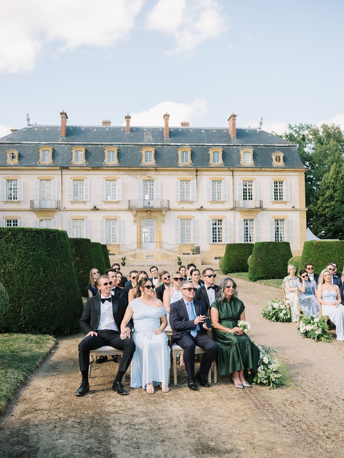 Guests seated for the ceremony with the chateau behind