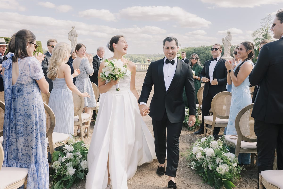 Haley and Tyler walking back up the aisle as guests applaud