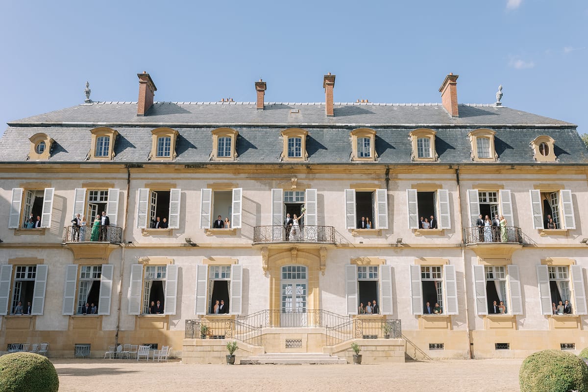 The facade of La Chassagne with guests at the open windows