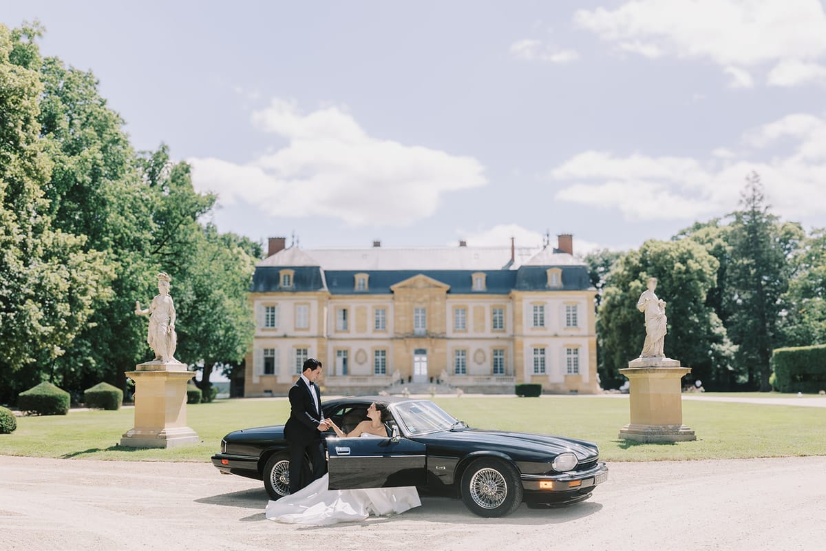 The vintage car in front of La Chassagne and its formal gardens