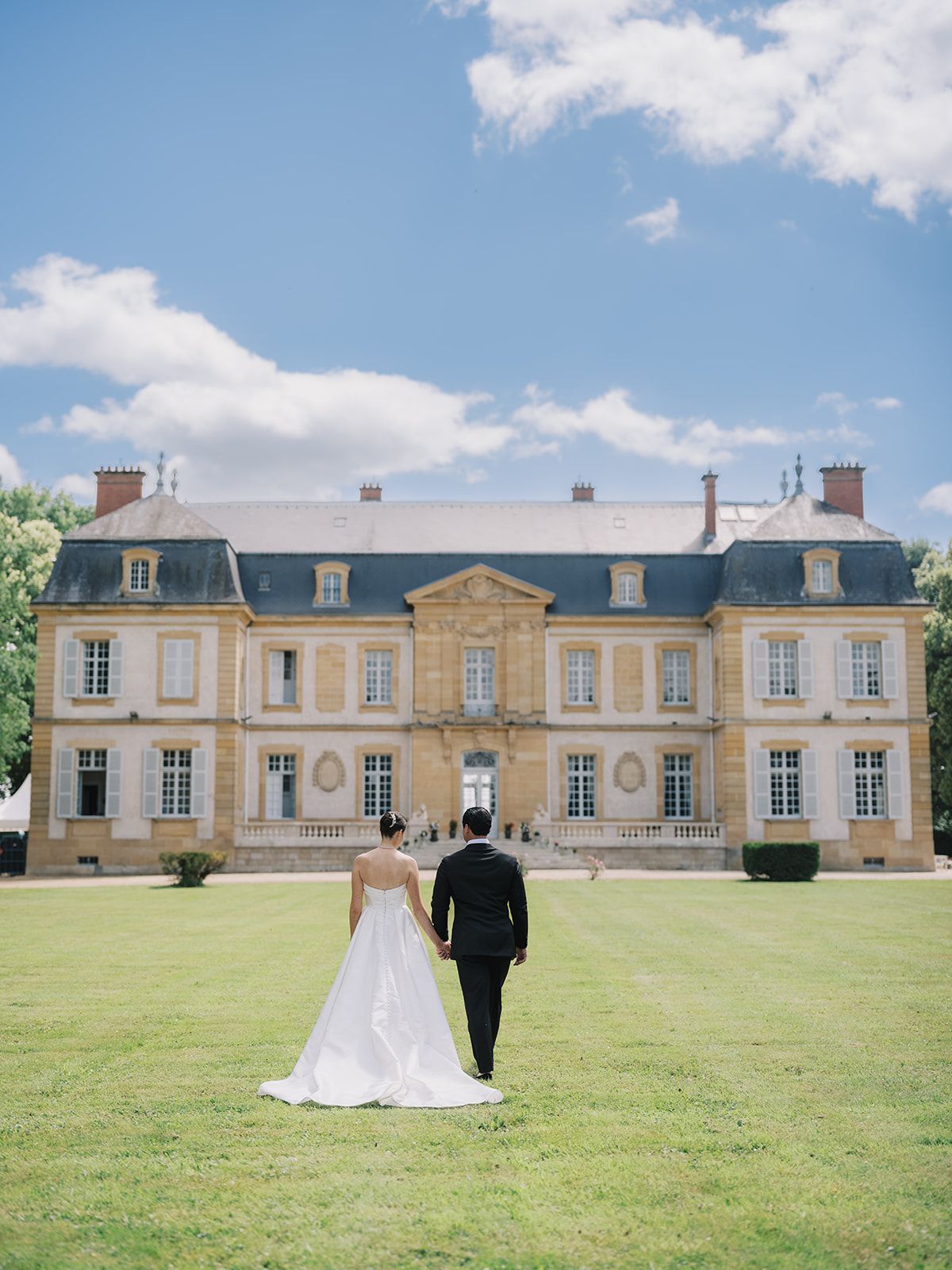Haley and Tyler walking hand in hand toward the chateau