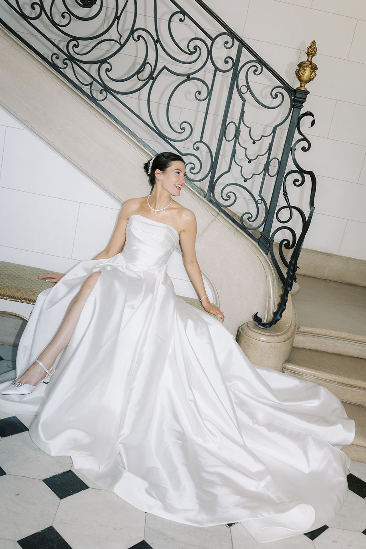 Haley seated on the staircase with her gown spread around her