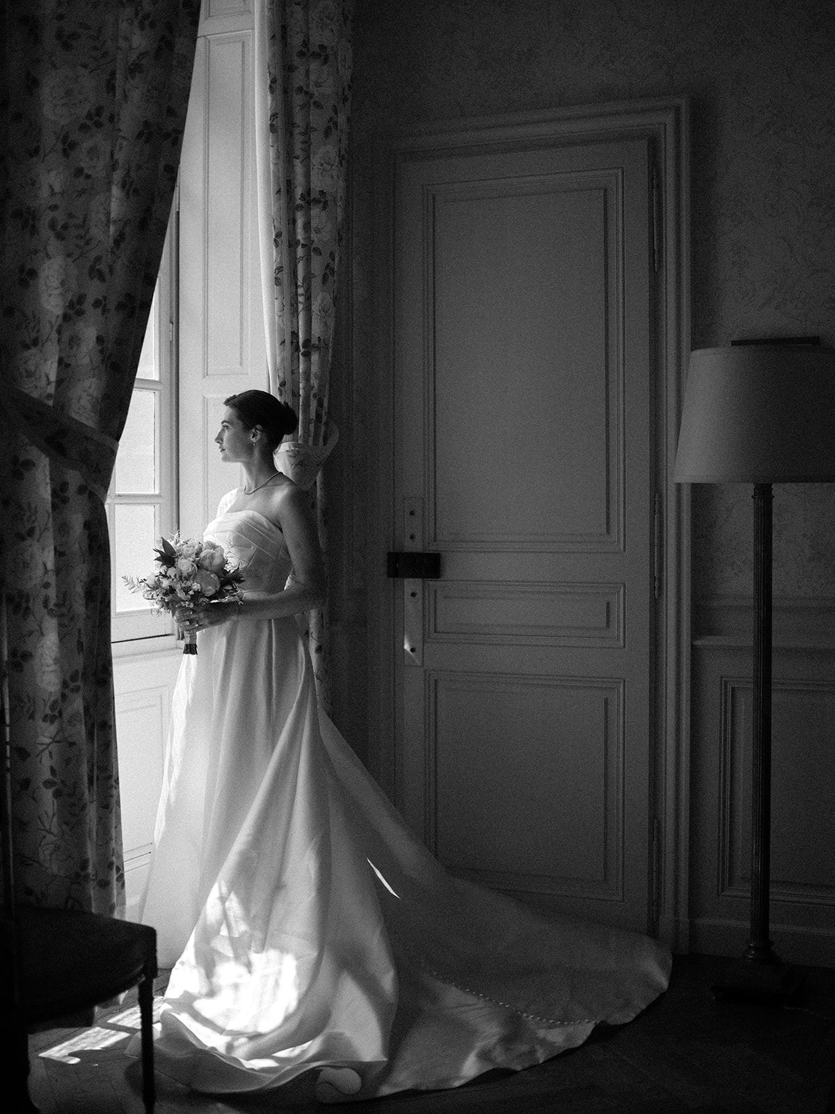 Haley with her bouquet beside a doorway at La Chassagne