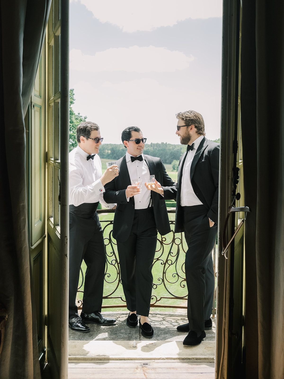 Tyler and his groomsmen with a drink on the balcony
