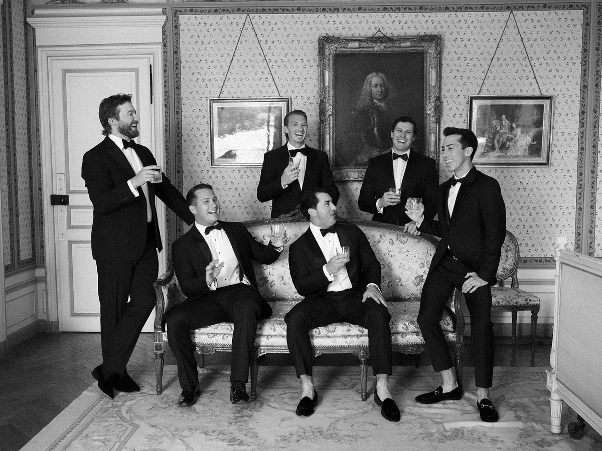 The groomsmen in black tie in a panelled sitting room