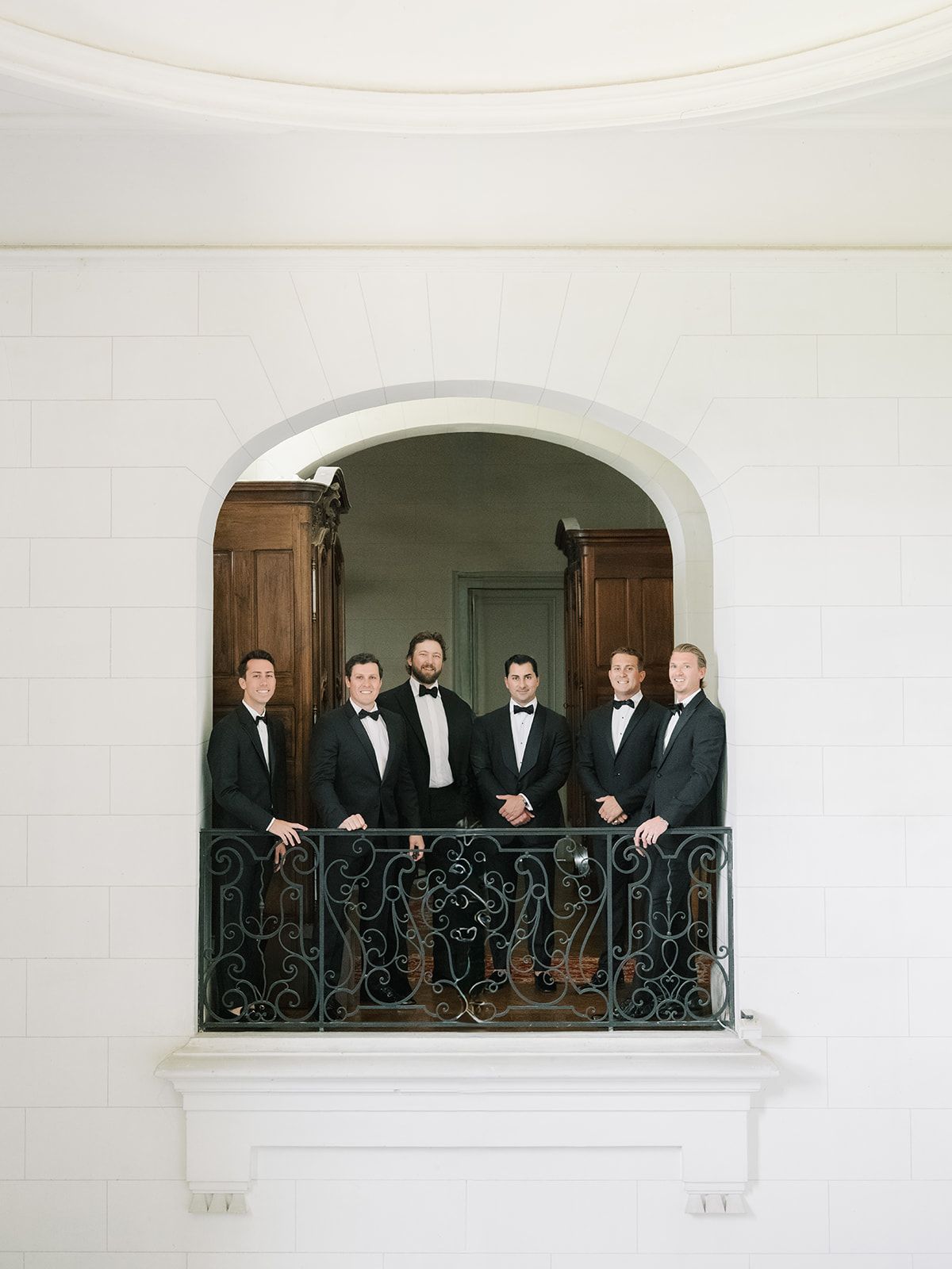The groomsmen at the balcony window of the chateau