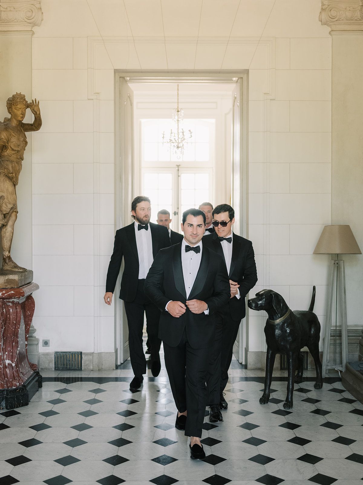 Tyler walking through the marble hall with his groomsmen