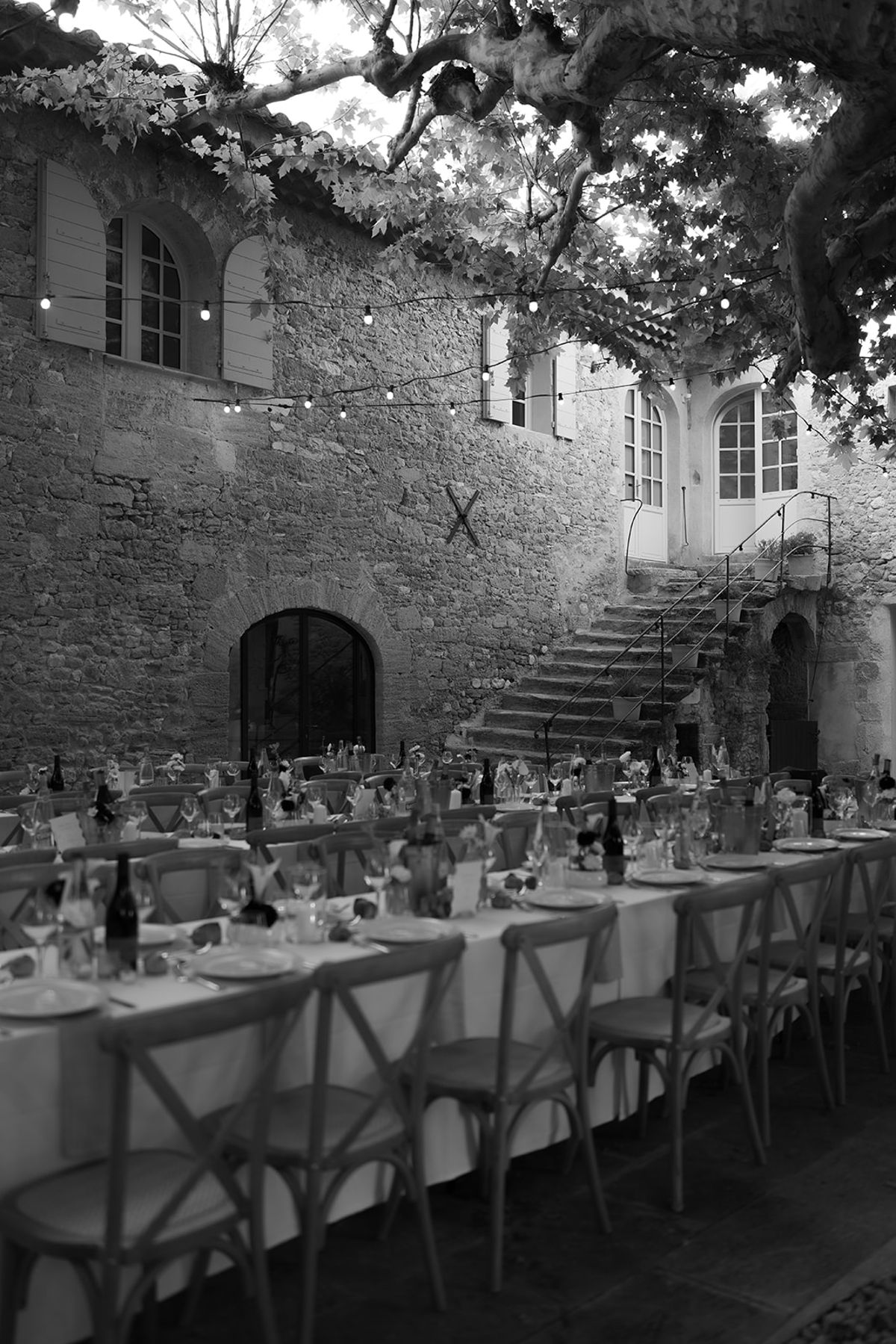 The courtyard of Le Petit Roulet laid for dinner, seen from beneath the plane trees