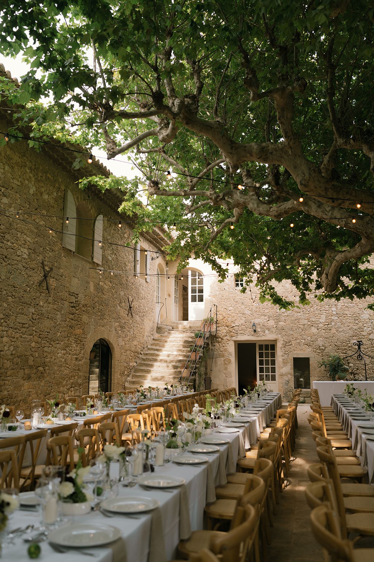 The stone courtyard at Le Petit Roulet with its outdoor staircase and plane trees