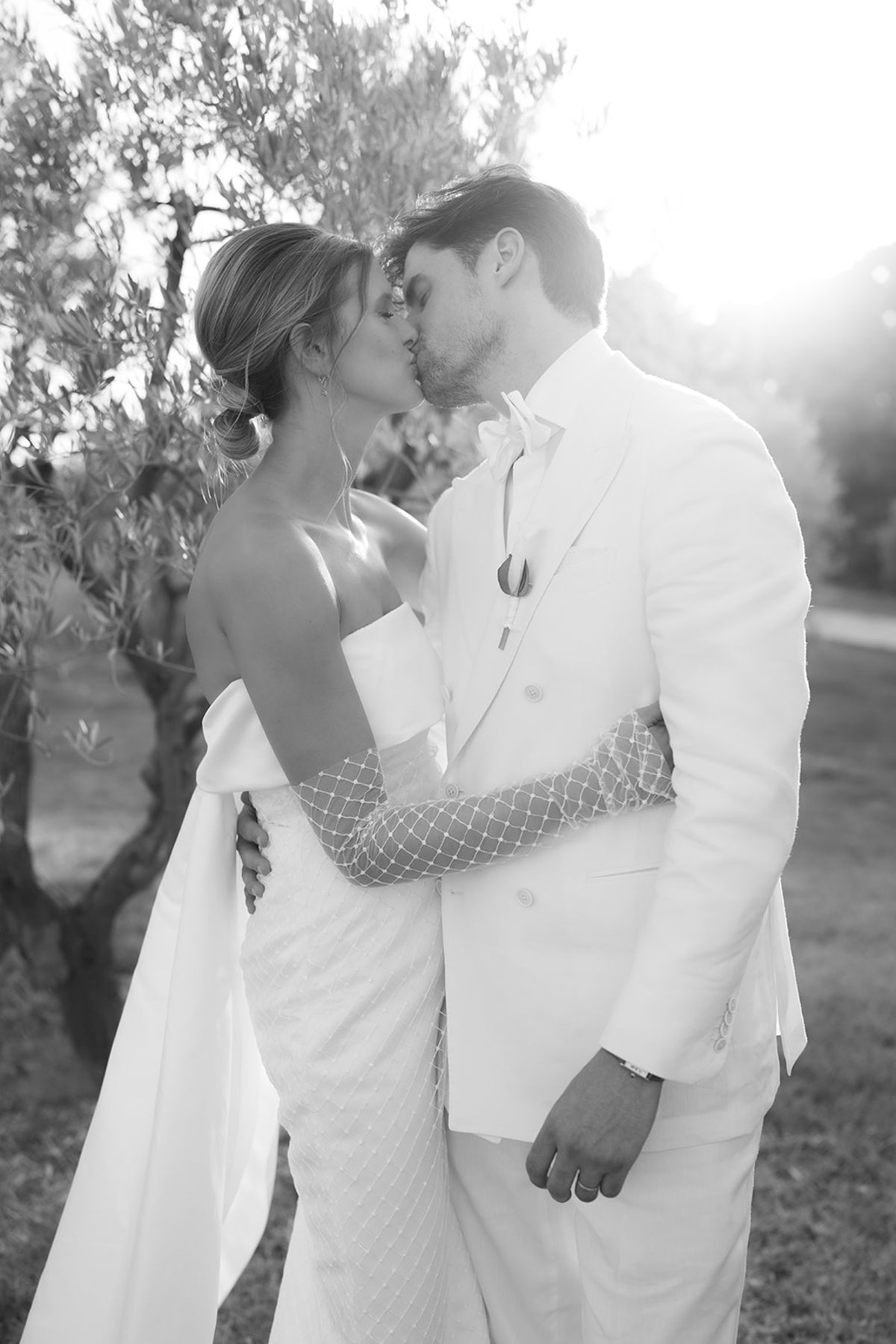 Jolien and Maxime kiss among olive trees in the late afternoon
