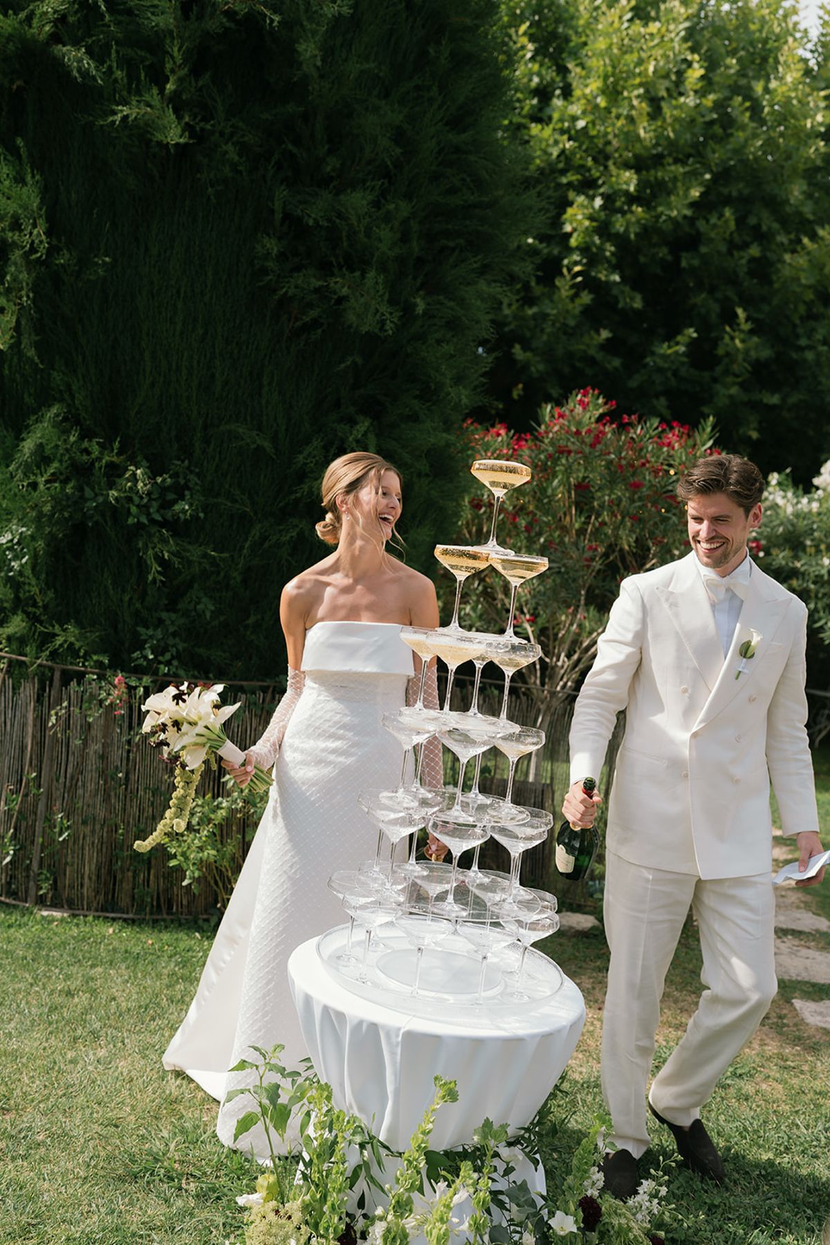 The bride and groom beside the champagne fountain on the lawn