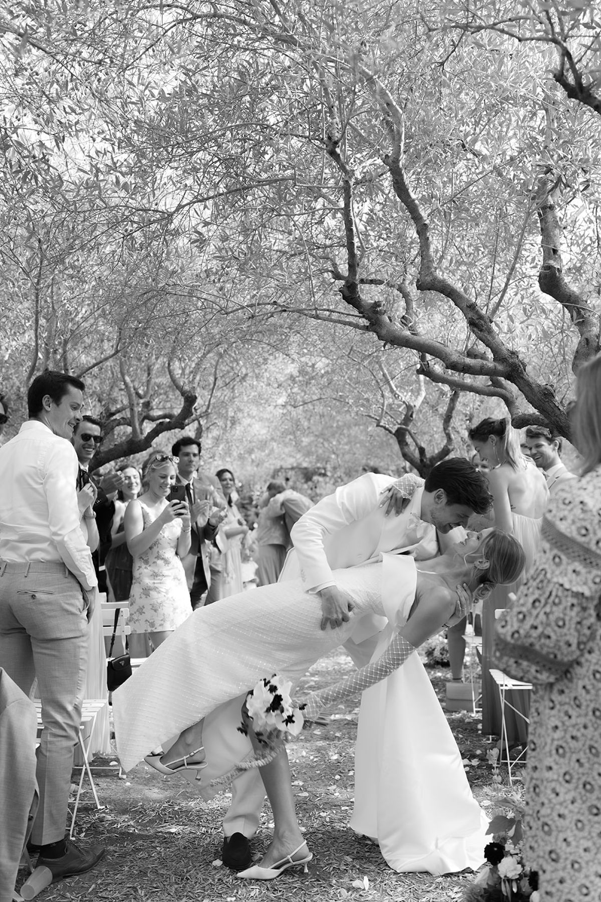 The groom dips the bride for a kiss in the aisle