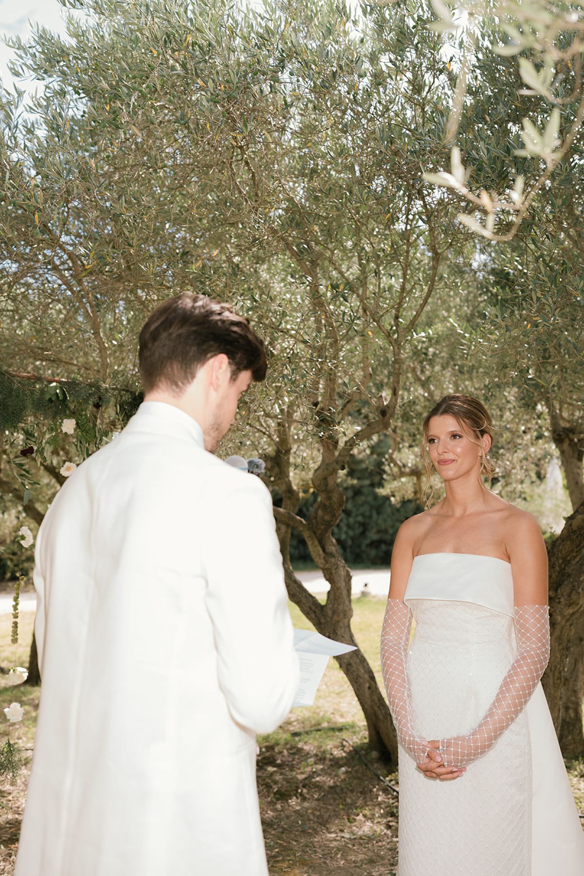 The groom reads from a card to the bride during the ceremony