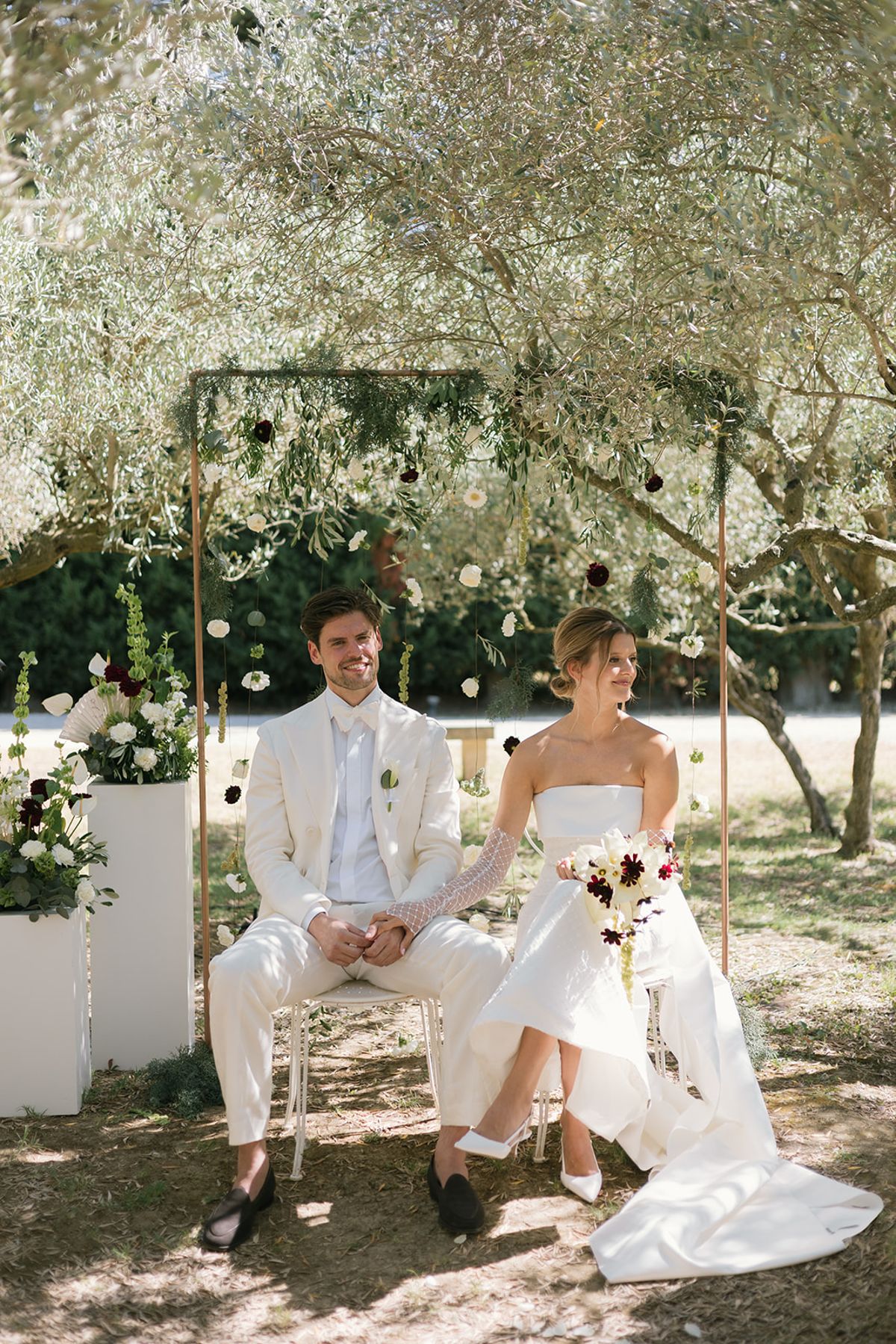 Jolien and Maxime seated side by side at their ceremony in the olive grove